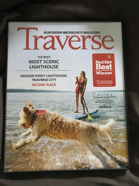 Cover of Traverse Magazine with dog, beach, woman on paddle board