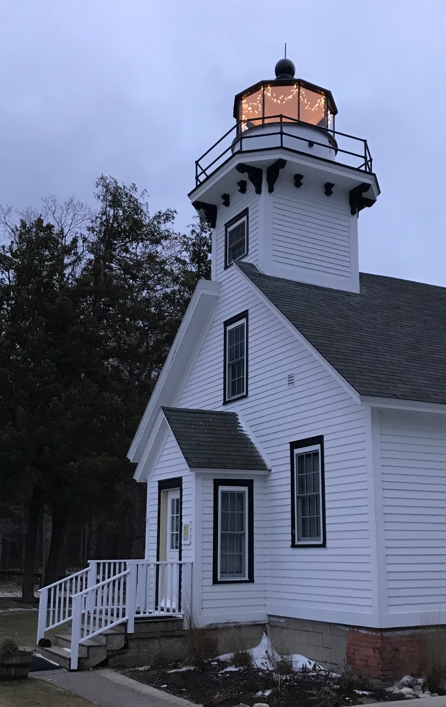 View of lighthouse with tower lantern deck with holiday lights