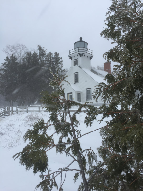 winter snow in front of light house with trees