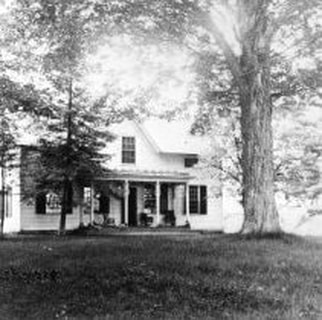 Black and white photo of old white farmhouse