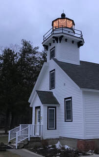 View of lighthouse with tower lantern deck with holiday lights