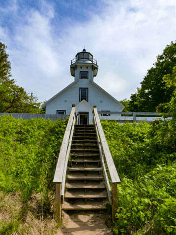 Stairway up to front of white lighthouse